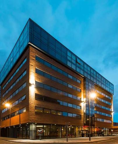 Glazed upper storeys and street-level frontage at dusk